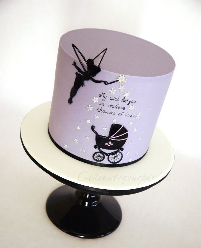 a purple and white cake with a tinker baby carriage on it's side