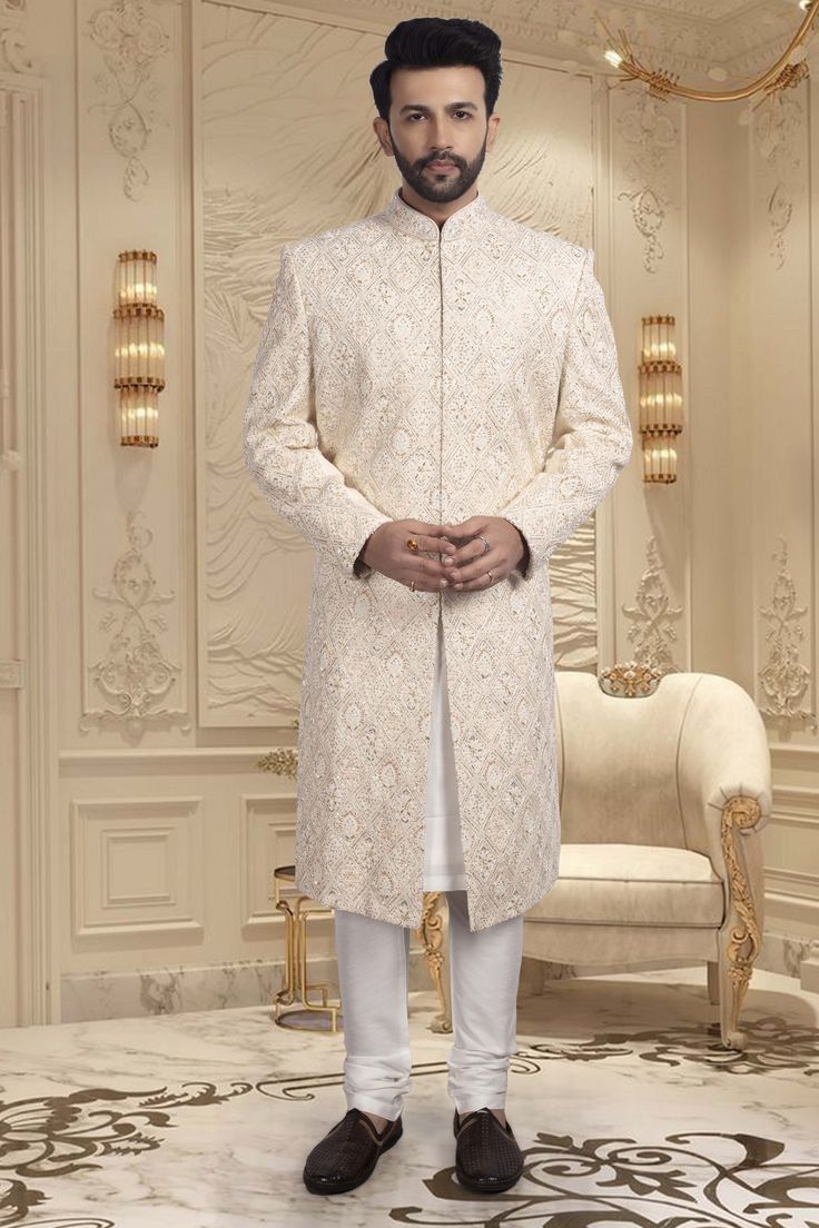 Introducing our Mens Sherwani R14-S66, a luxurious and sophisticated choice for grooms. Adorned with intricate zardozi embroidery, this sherwani exudes elegance and exclusivity. Make a statement on your special day with this magnificent piece. Off White Naqshi Bandhgala, Cream Nehru Jacket With Chikankari Embroidery For Reception, Cream Nehru Jacket For Eid Reception, Off White Sherwani With Chikankari Embroidery For Reception, Off White Sherwani With Chikankari Embroidery For Formal Occasions, Off-white Dabka Sherwani For Transitional Seasons, Elegant Traditional Wear With Naqshi, Elegant Traditional Wear With Naqshi Drape, Elegant Traditional Wear With Naqshi In Traditional Drape