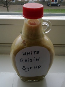 a bottle with some type of sauce in it sitting on a window sill next to a window