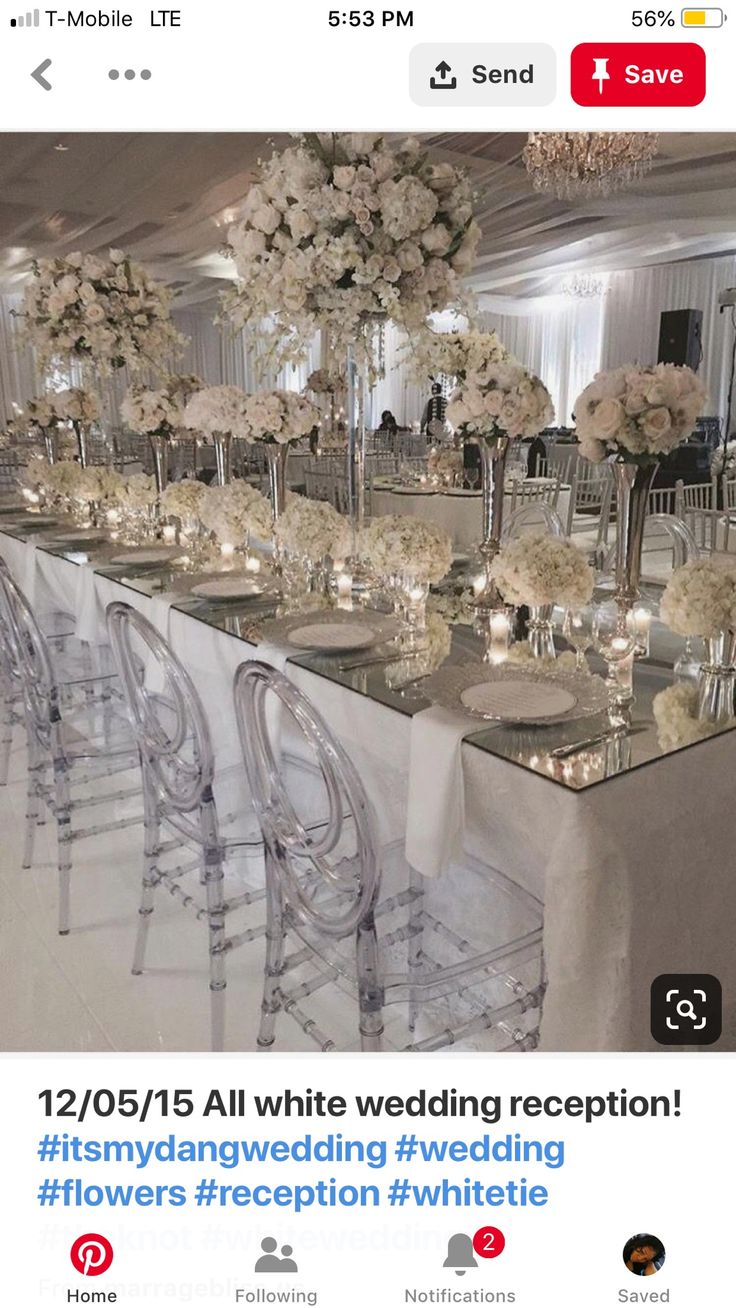 the wedding reception table is set up with clear chairs and white flowers in vases