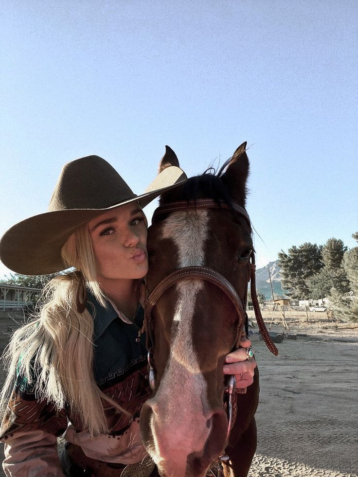 a woman wearing a cowboy hat sitting on top of a horse