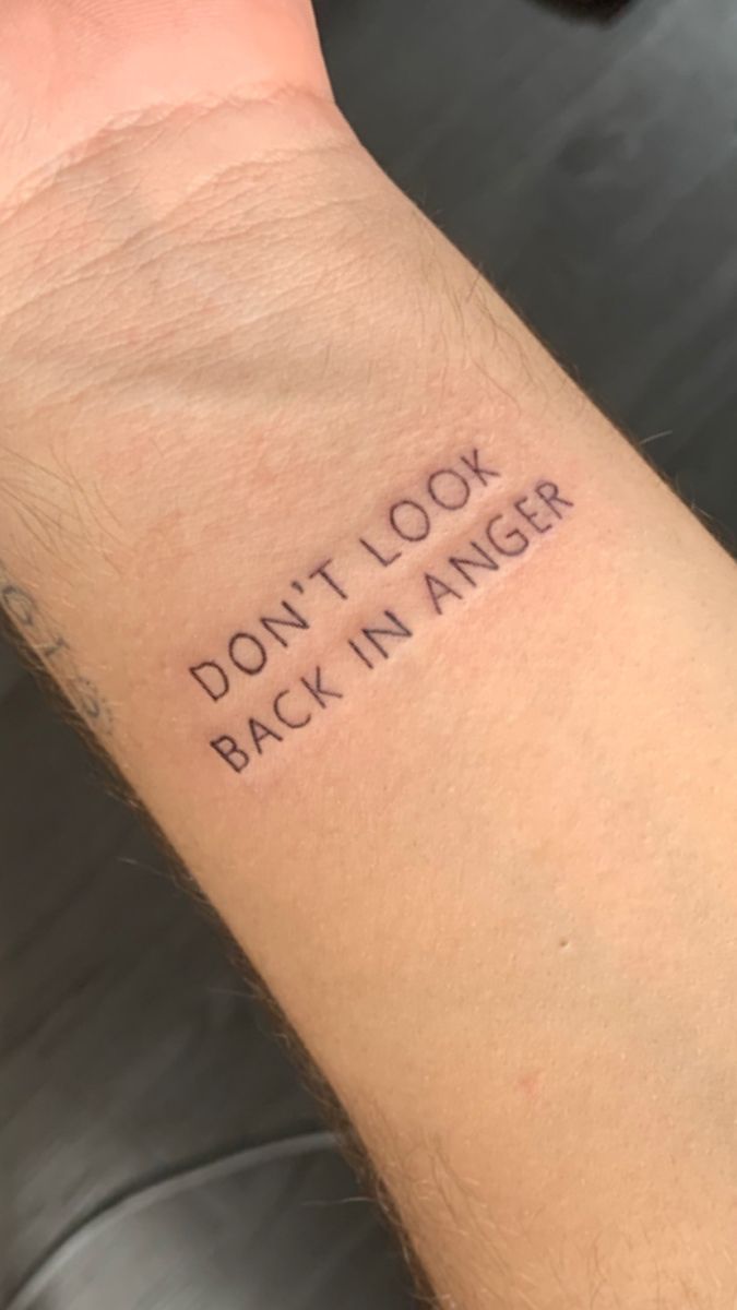 a man's arm with the words don't look back in anger written on it