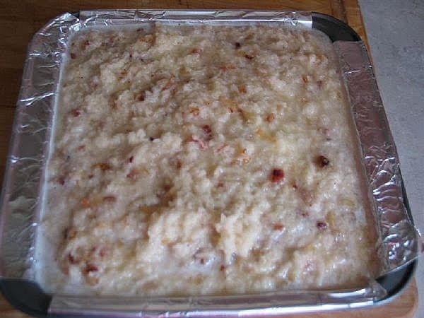 an uncooked casserole dish sitting on top of a wooden table