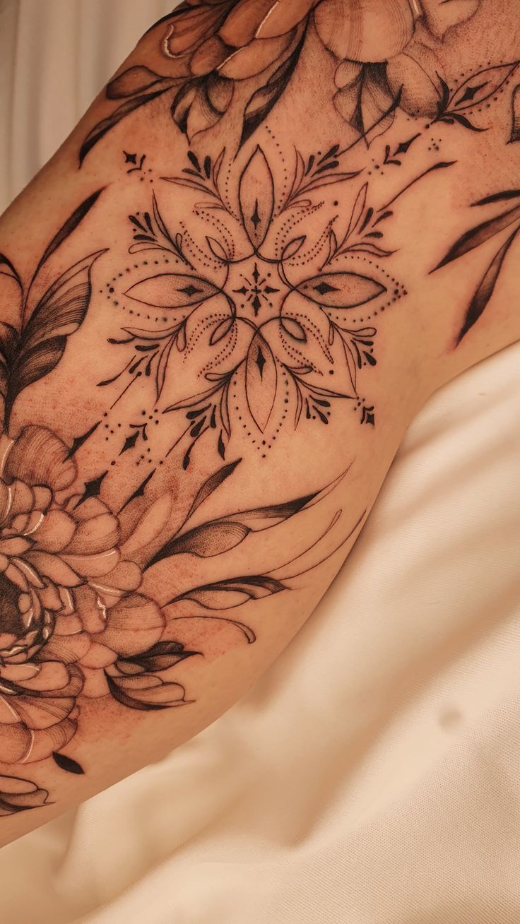 a woman laying on top of a bed covered in tattoos