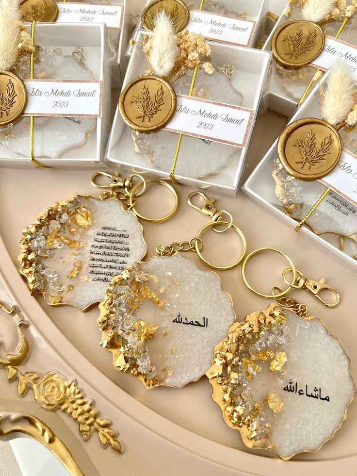 some gold and white items are on a table with tags attached to the key chains