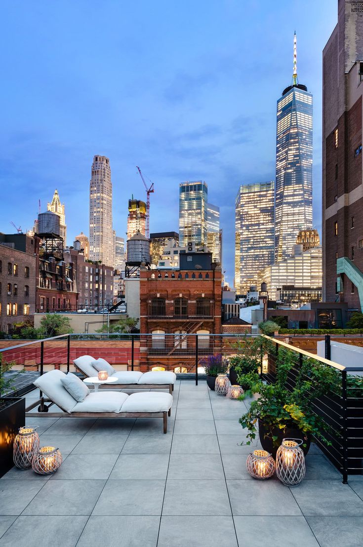 an outdoor seating area with city lights in the background