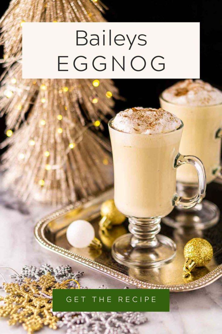 two glasses of eggnog on a tray with christmas decorations