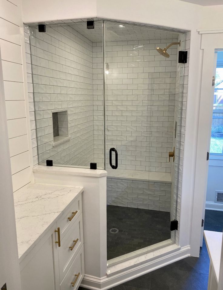 a walk in shower sitting inside of a bathroom