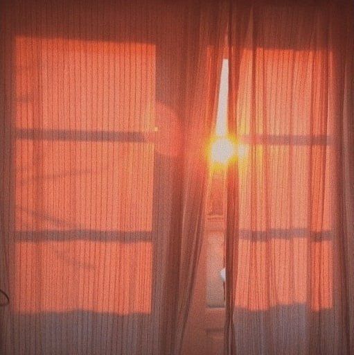 the sun is shining through some curtains