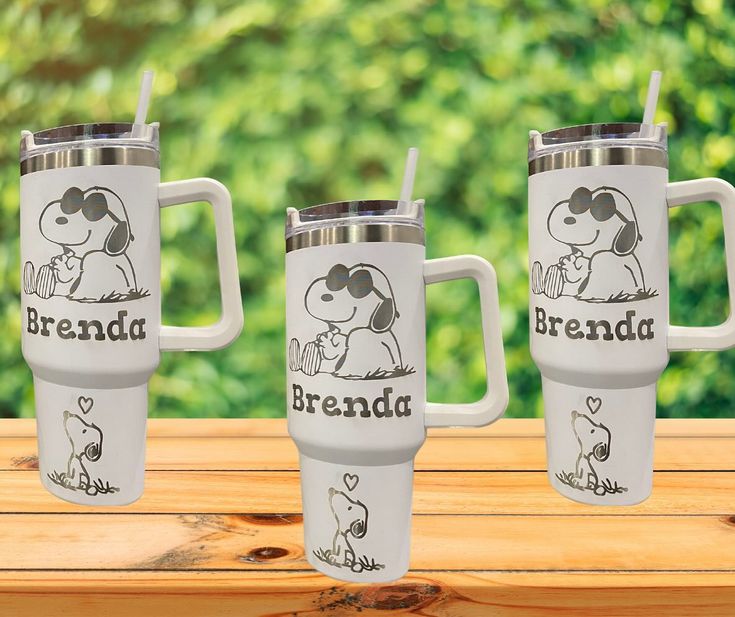 three stainless steel travel mugs with the words,'brenda'and a cartoon dog on them