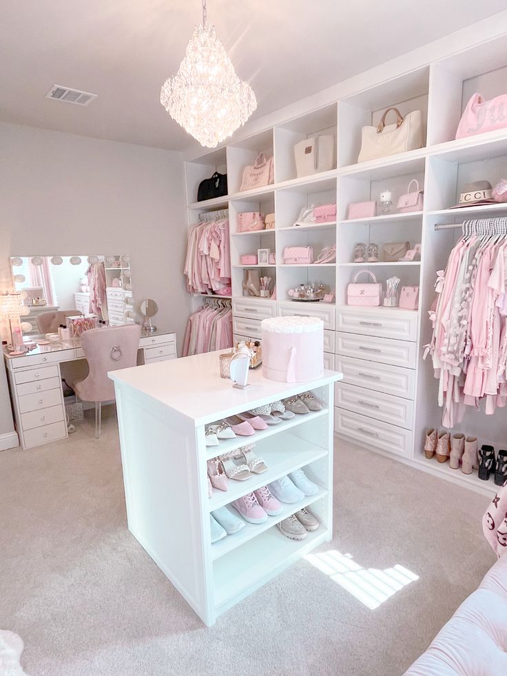 a white closet filled with lots of pink and white shoes next to a chandelier