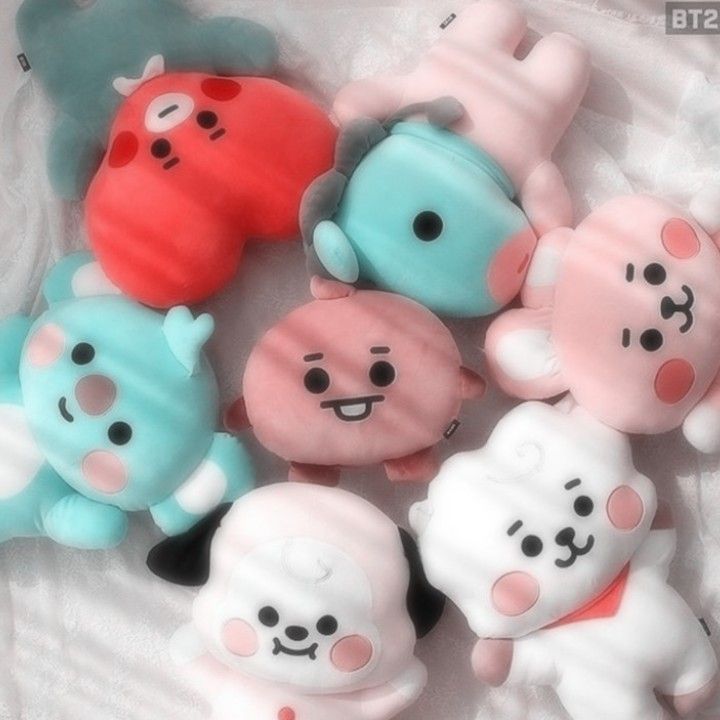 there are many small toy animals together on the bed sheet, one is blue and one is pink