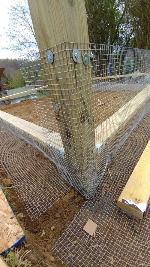 there is a fence that has been built in the ground with some wood and wire around it