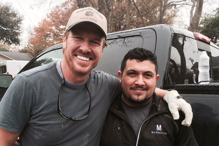 two men standing next to each other in front of a truck