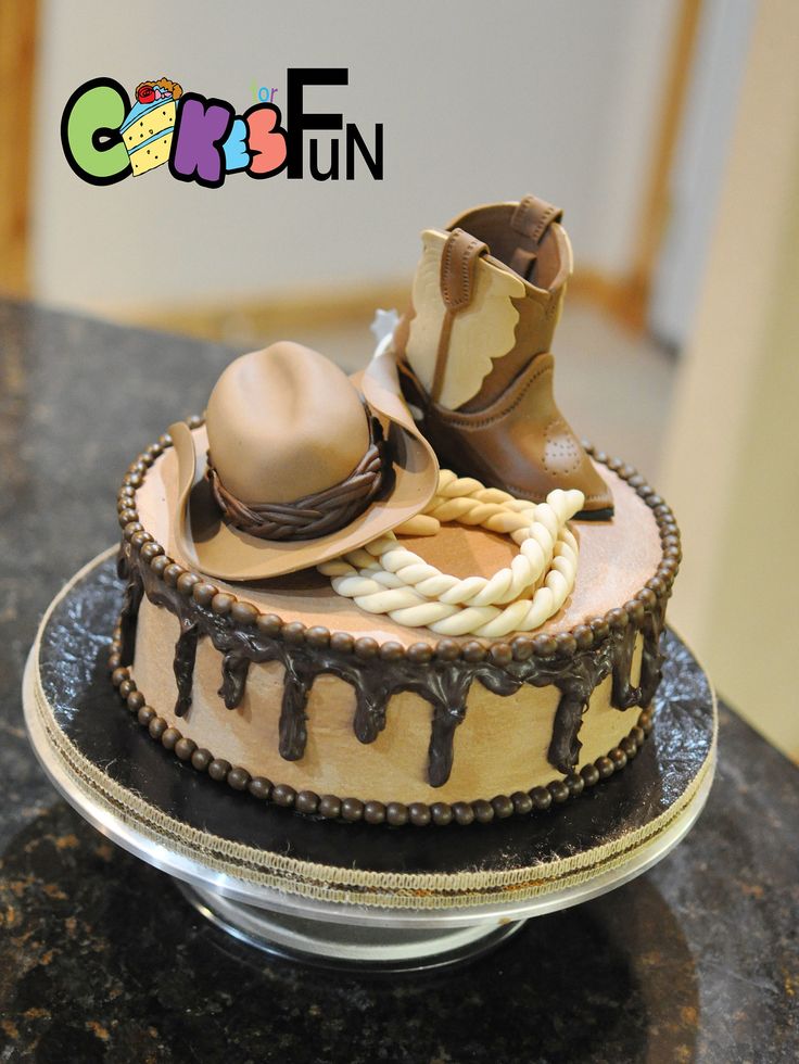 a cake decorated with cowboy hats and boots on a plate that is sitting on a table