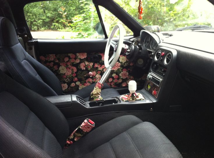 the interior of a car with floral seat covers and dash stickers on it's dashboard