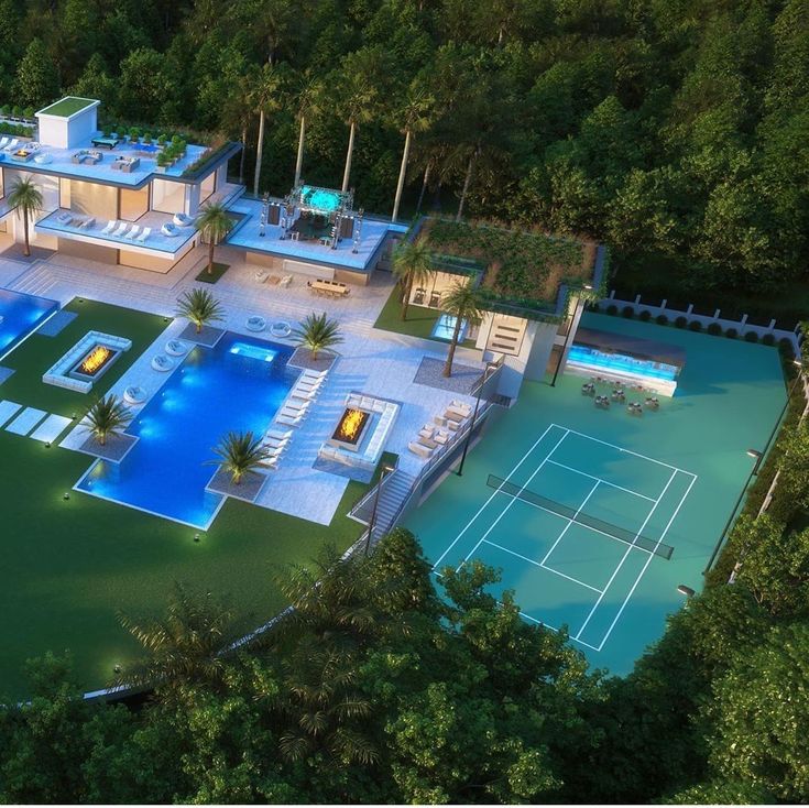 an aerial view of a tennis court and swimming pool in the middle of a wooded area