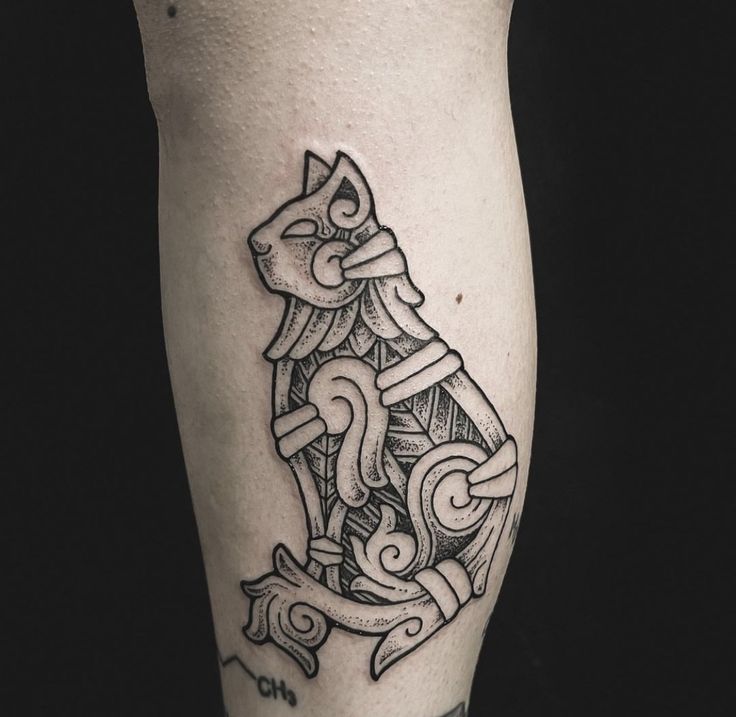 a black and white photo of a cat tattoo design on the right calf's leg