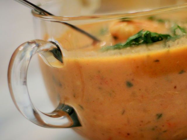 a glass pitcher filled with soup sitting on top of a table