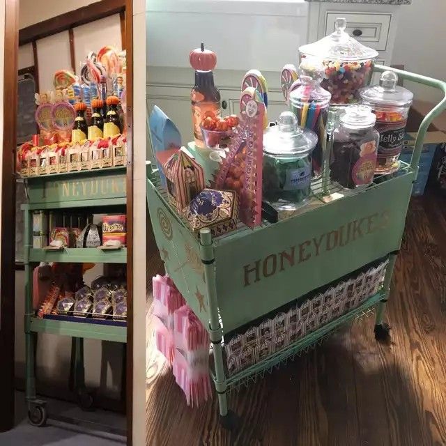 a green cart filled with lots of candy and candies on top of a hard wood floor