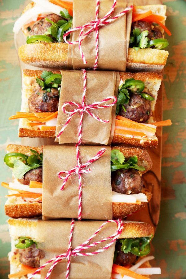 sandwiches wrapped in brown paper and tied with twine on top of eachother