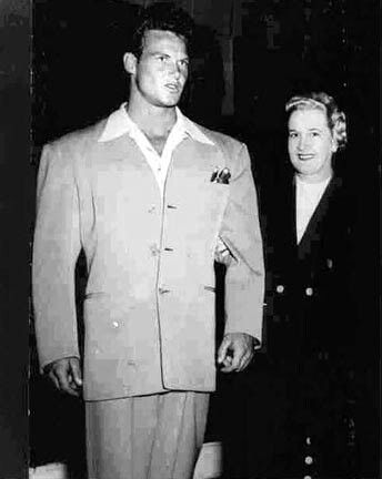 an old black and white photo of two men in suits standing next to each other