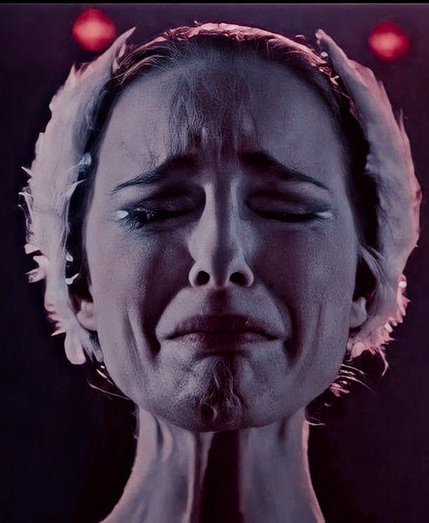 a woman with her eyes closed in front of the camera and red lights behind her