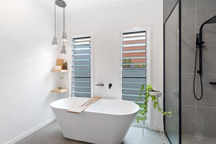 a white bath tub sitting inside of a bathroom next to a walk in shower stall