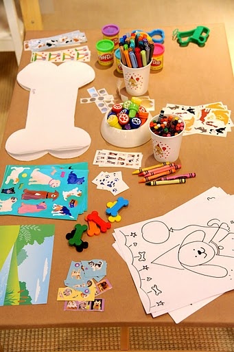 the table is covered with various children's artwork and crafts, including crayons