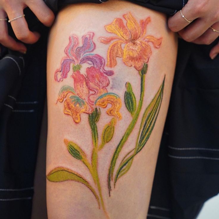 a woman's thigh with flowers painted on it