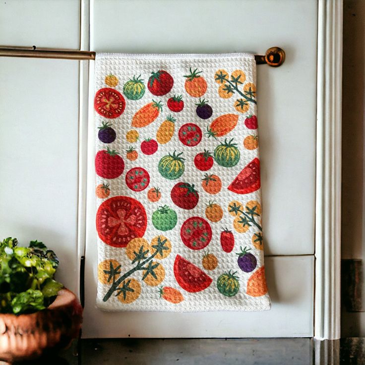 a potted plant sitting next to a kitchen towel hanging on a doorknob