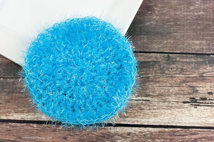 a round blue object sitting on top of a wooden table next to a white envelope