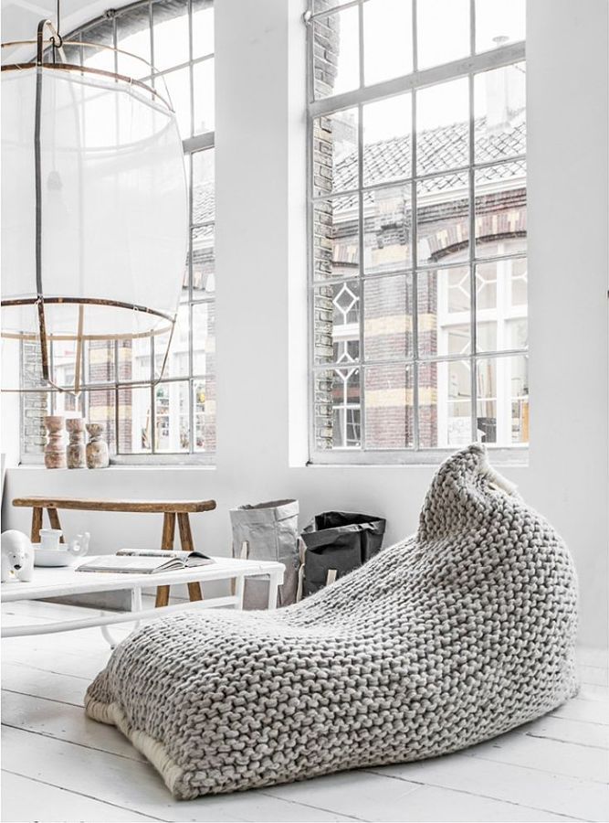 a bean bag chair sitting on top of a white floor next to a table and chairs