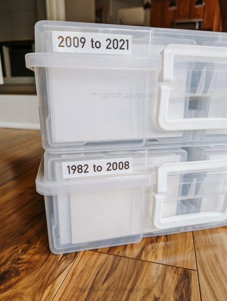 three plastic storage containers sitting on top of a wooden floor