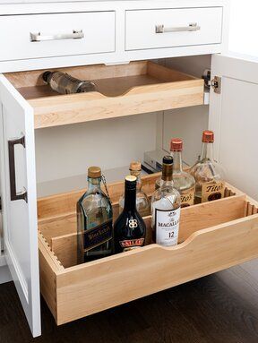 an open drawer with liquor bottles in it