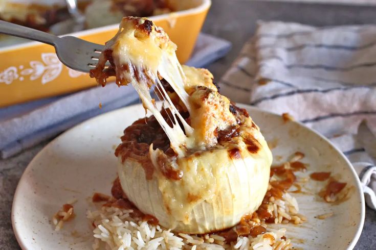 a plate with some food on it and a fork sticking out of the top one