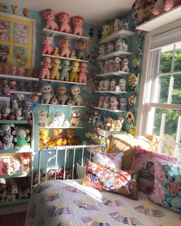 a bed room with a neatly made bed and lots of stuffed animals on the wall