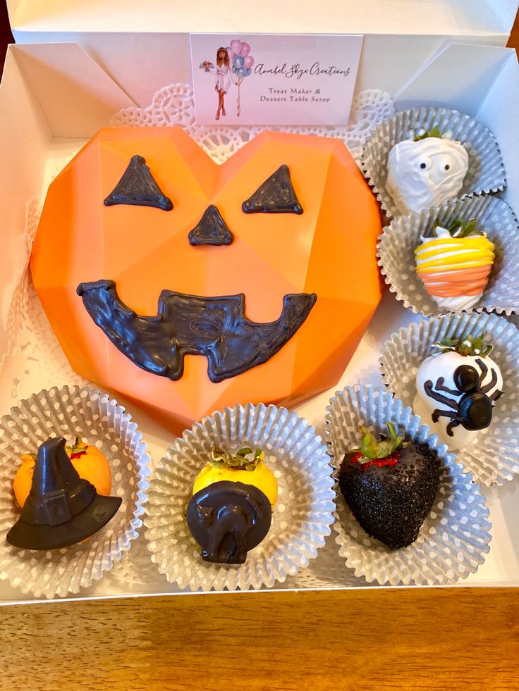 a box filled with cupcakes decorated like jack - o'- lanterns