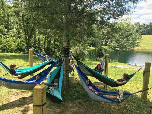 several people relaxing in hammocks by the water