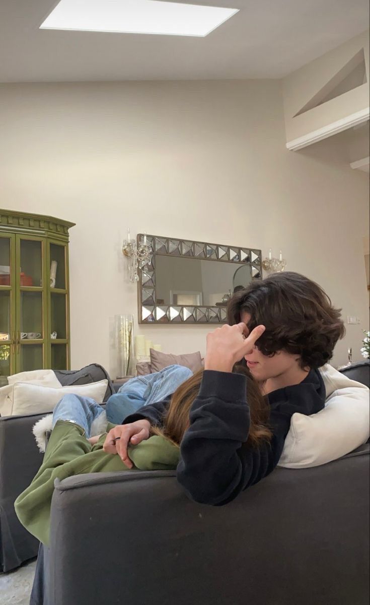 a man and woman sitting on a couch in a living room