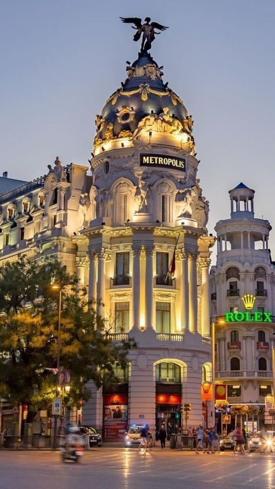 a tall building with an eagle on top in the middle of a city at night