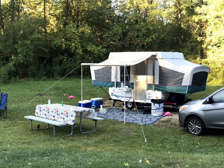 an rv is parked in the grass next to a picnic table