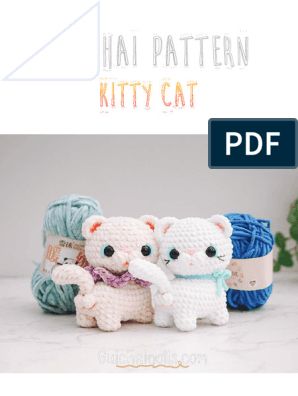 two crocheted cats sitting next to each other with yarn balls in the background