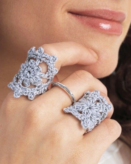 a woman wearing a crocheted ring with two rings on her fingers