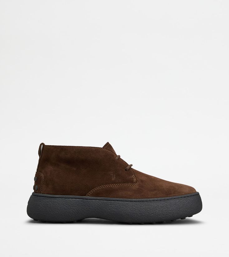 Characterized by a chunky but at the same time sober and refined outsole, the Tod's W. G. style is here proposed in desert boot version. Crafted in suede, with iconic rubber pebbles on the bottom and heel, they are enhanced by Tod's monogram stamped on the front. Modern Suede Boots With Contrast Sole, Casual Calf Leather Boots With Textured Sole, Casual Calf Leather Chukka Boots With Stitched Sole, Casual Calf Leather Boots With Contrast Sole, Modern Chukka Boots With Textured Sole, Desert Boot, Desert Boots, Chukka Boots, Ankle Boot