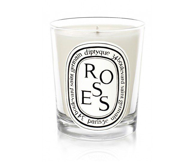 a glass candle with the words roses on it