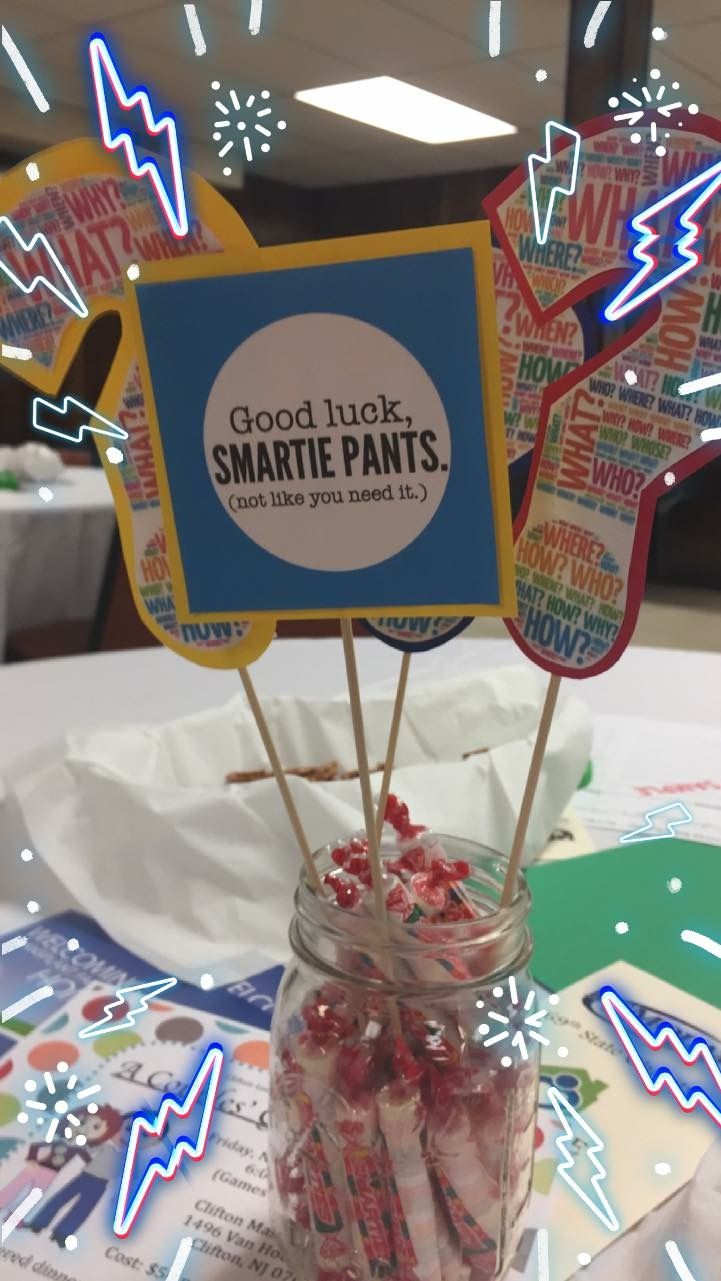 some candy sticks are in a jar on top of a table with a sign that says good luck, smartie pants