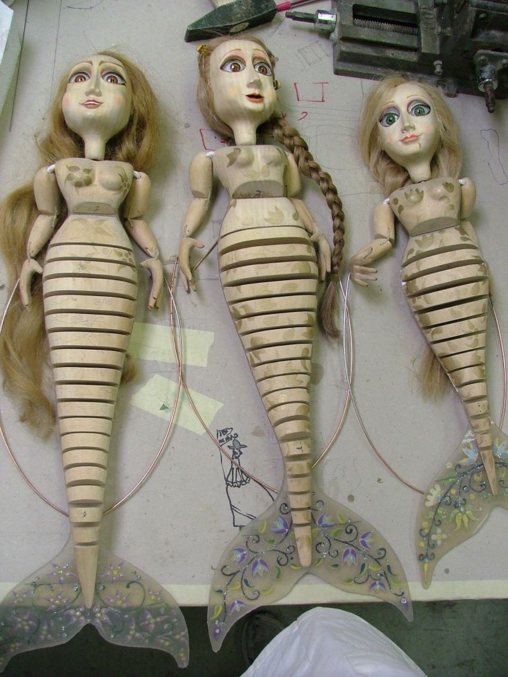 three dolls made to look like mermaids with long hair and braids on their heads