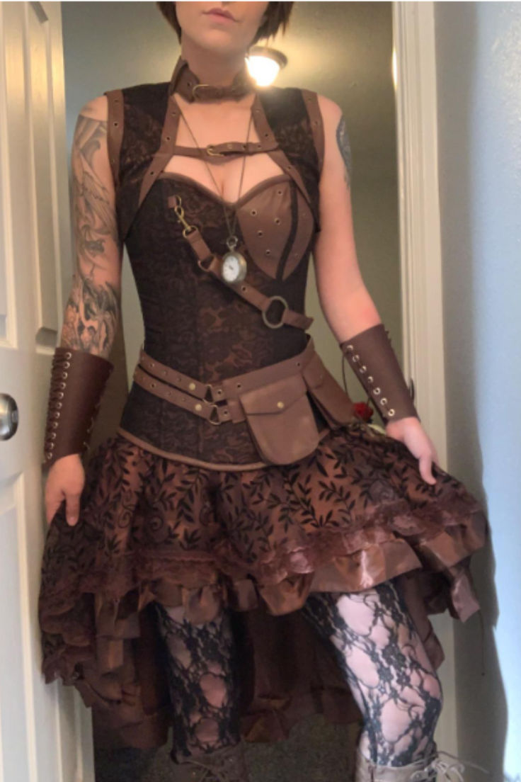 woman wearing a Steampunk costume outfit Steampunk Fitted Costume For Cosplay Events, Steampunk Fitted Cosplay Costume For Costume Party, Steampunk Fitted Cosplay Costume For Events, Steampunk Cosplay Costume Fitted For Cosplay Events, Steampunk Cosplay Costume For Events, Fitted Steampunk Cosplay Costume, Steampunk Fitted Corset For Cosplay Events, Fitted Steampunk Overbust Costume, Punk Style Corset For Cosplay Events