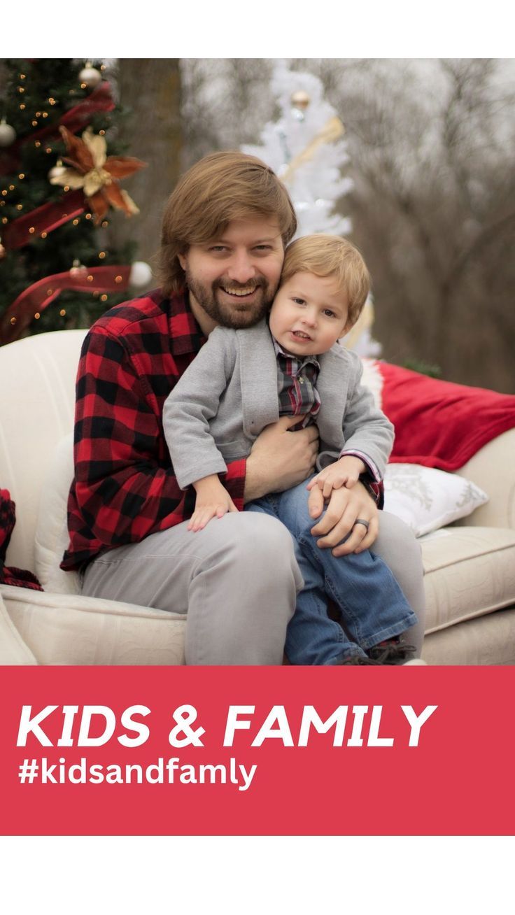 a man sitting on top of a white couch holding a child